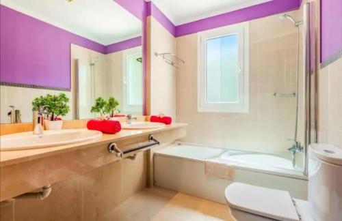 ein Badezimmer mit zwei Waschbecken, einer Badewanne und einer Dusche in der Unterkunft Villa Luna in Yaiza