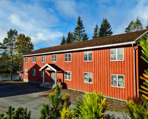 um celeiro laranja com garagem em Skogsro Forest Hostel em Steinsholt