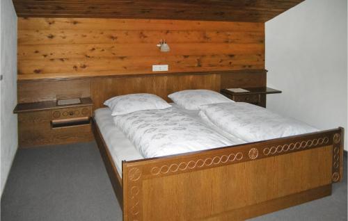 a large wooden bed with two pillows on it at Stunning Apartment In Reith Im Alpbachtal With 3 Bedrooms And Wifi in Brixlegg