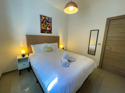 a bedroom with a white bed with two towels on it at NEW YORK by luxury atitlan in San Pedro La Laguna