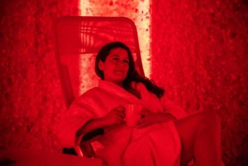 a woman sitting in a red chair holding a cup at Hotel Residence Montelago in Ternate