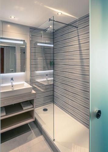 a bathroom with a glass shower and a sink at Best Western Marseille Aeroport in Vitrolles