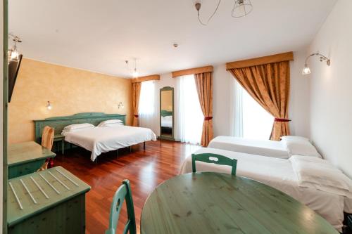 a hotel room with two beds and a table at Hotel Residence Montelago in Ternate