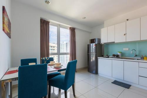 een keuken met een tafel en blauwe stoelen in een kamer bij Mansion One by Stay Premium in George Town