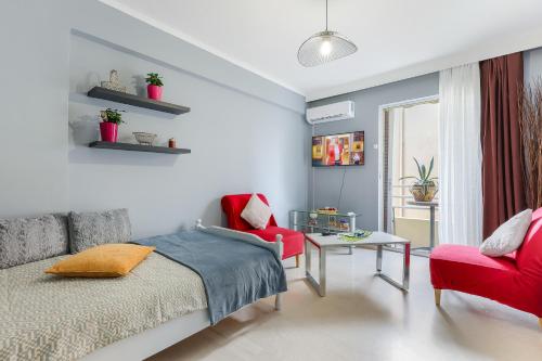 ein Schlafzimmer mit einem Bett und einem roten Stuhl in der Unterkunft Thanasis Family Apartment in Athen
