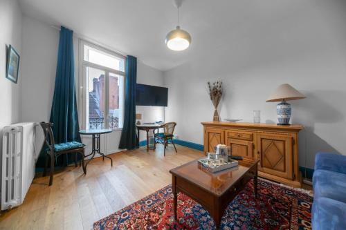ヴィシーにあるLe Darcet - Appartement Calme et lumineuxのリビングルーム(青いソファ、テーブル付)