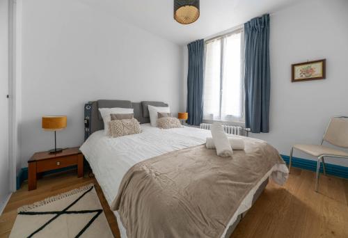 ヴィシーにあるLe Darcet - Appartement Calme et lumineuxのベッドルーム(大型ベッド1台、椅子付)