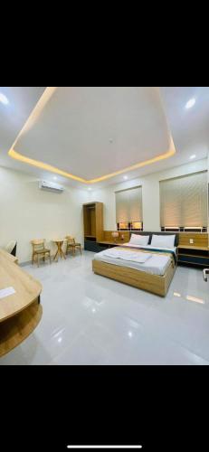 um quarto grande com uma cama grande e mesas em Khách sạn An An em Xã Trảng Bôm