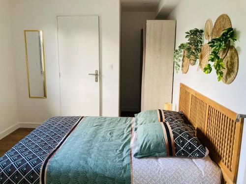 a bedroom with a bed with a blue comforter at Le gîte de Mireloup in Plerguer