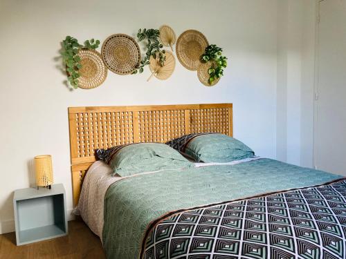 1 dormitorio con 1 cama con sombreros en la pared en Le gîte de Mireloup, en Plerguer