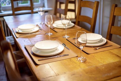 a wooden table with plates and wine glasses on it at Sylthause in Archsum