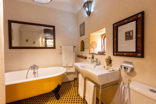 a bathroom with a tub and a sink at Riad Asrari in Marrakesh