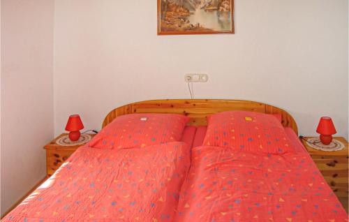 a bedroom with two beds with red sheets and two lamps at Awesome Apartment In Thiersee With 2 Bedrooms And Wifi in Thiersee