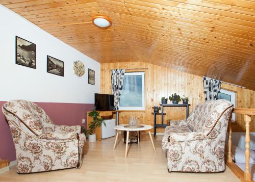 a living room with two chairs and a table at Penzion Sport in Smokovce
