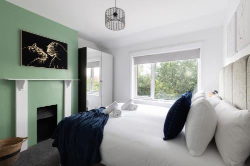 a bedroom with a large white bed with blue pillows at Properties Unique Cleveland House in Stockton-on-Tees
