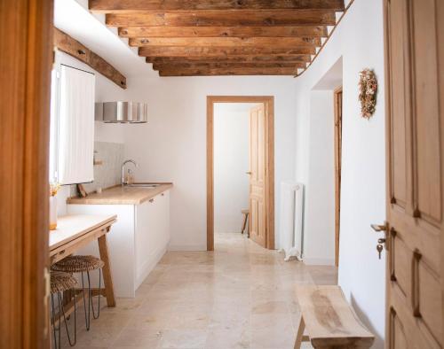 una cucina con pareti bianche e soffitto in legno di El Bálsamo - Hotel Boutique 5 Estrellas a Belmonte