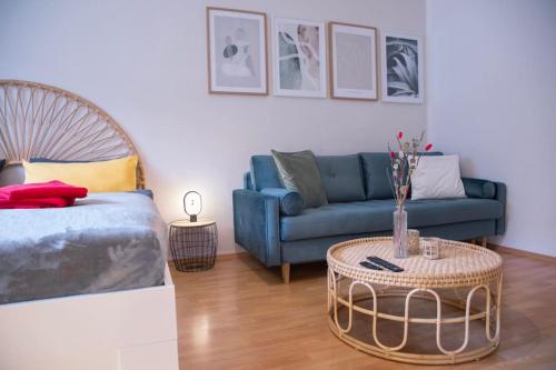 ein Wohnzimmer mit einem blauen Sofa und einem Tisch in der Unterkunft Stilvolles Appartement zwischen Messe und HBF in Essen