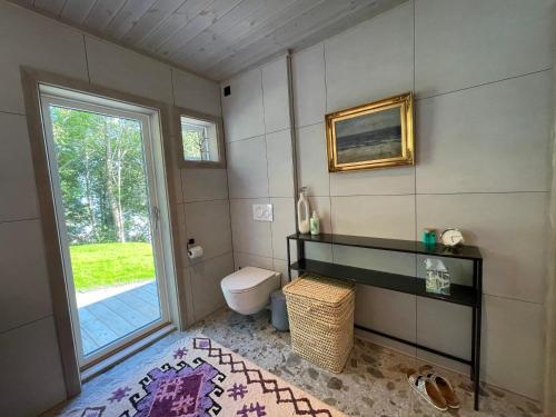 a bathroom with a toilet and a window at Villa Blue Dream in Kristiansund