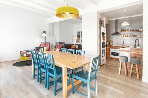 a kitchen and dining room with a wooden table and blue chairs at Silver Coast - Casa da Lagoa in Foz do Arelho