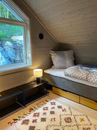 a bedroom with a bed and a window and a rug at Villa Blue Dream in Kristiansund