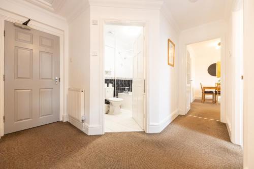 a white bathroom with a toilet and a sink at The Burton- Free Gated Parking in Manchester