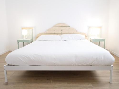uma cama branca com lençóis e almofadas brancos em Anita Bnb Rimini em Rimini