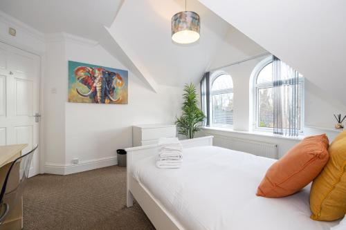 1 dormitorio con 1 cama blanca y 2 ventanas en The Burton- Free Gated Parking, en Mánchester