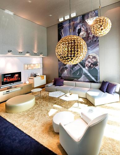a living room with a couch and a tv at Sofitel Munich Bayerpost in Munich