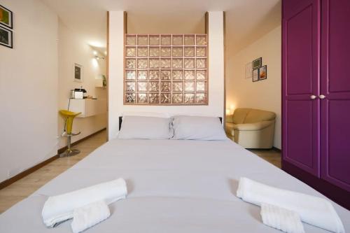a large white bed in a room with purple cabinets at LUMINOSO APPARTAMENTO Via MERCATO VECCHIO in Udine