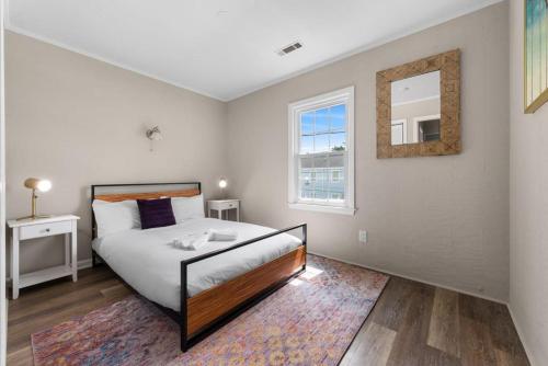 1 dormitorio con cama y espejo en la pared en Viagem Bright 2BR Parking 1 Block to the Beach, en Myrtle Beach
