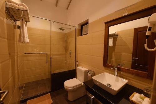 y baño con aseo, lavabo y ducha. en Seasons Hotel en Kurunegala