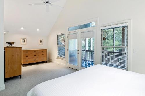1 dormitorio con 1 cama, vestidor y ventanas en 7 Ocean Green en Kiawah Island