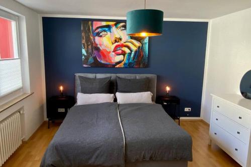 a bedroom with a bed with a painting on the wall at Schickes 2-Zimmer Appartement Messe Rü Innenstadt in Essen