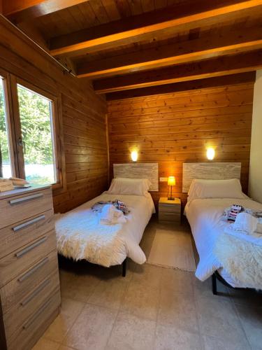 1 dormitorio con 2 camas en una cabaña de madera en L'Oreneta, en Incles