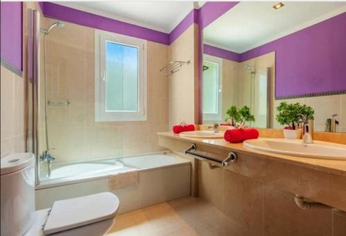 Un baño con dos lavabos, una bañera y un inodoro. en Villa Mar, en Playa Blanca