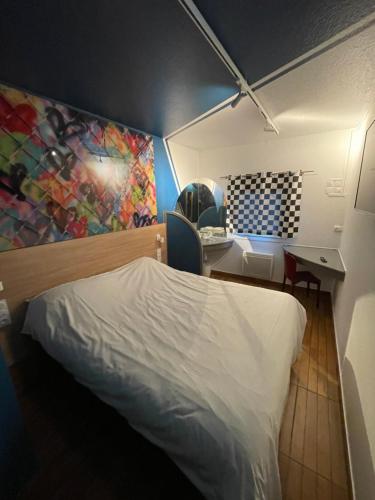 um quarto com uma cama, uma secretária e um quadro em Egg Hôtel Sarcelles em Sarcelles