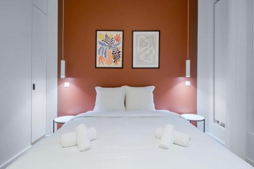 ein Schlafzimmer mit einem großen weißen Bett mit drei Bildern an der Wand in der Unterkunft B.Appart 6Pers#2Bedrooms#VictorHugo#ArcDeTriomphe in Paris