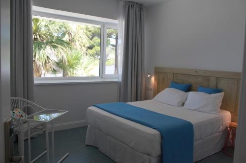 a bedroom with a large bed and a window at Guadalupe Hotel Boutique in Los Caños de Meca