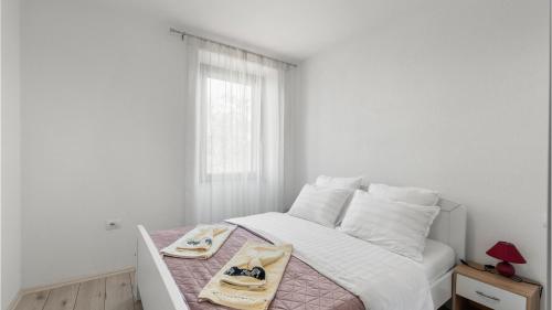 达伊拉Apartments Vorfi的白色卧室配有带2条毛巾的床