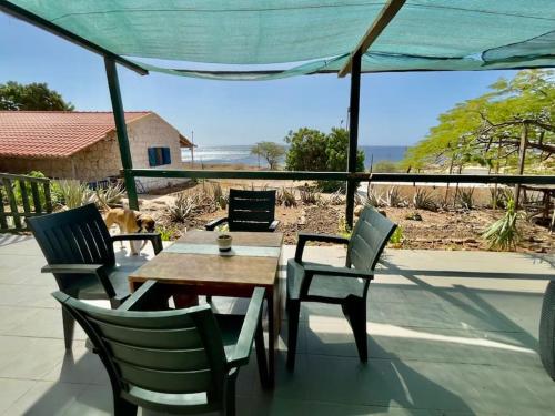 einen Tisch und Stühle auf einer Terrasse mit Meerblick in der Unterkunft Casa Aloé Vera - Private House w/ free Breakfast in Cidade Velha