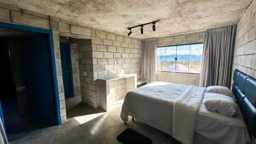 Un dormitorio con una cama grande y una ventana en Casa Concept, en Mucugê
