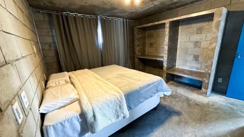 a bedroom with a bed in a brick wall at Casa Concept in Mucugê