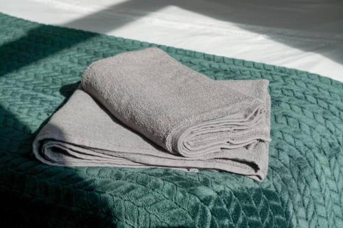 a pile of towels sitting on top of a bed at Charming 3-Bedroom Retreat in Barrow-in-Furness by Amazing Spaces Relocations Ltd. in Barrow in Furness