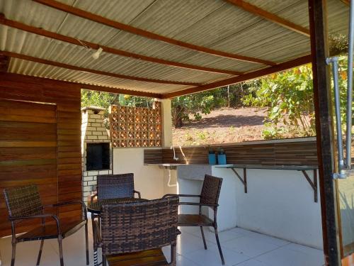 a patio with a wooden pergola with chairs and a table at CASA DA SERRA na Chácara Paraíso in Bananeiras