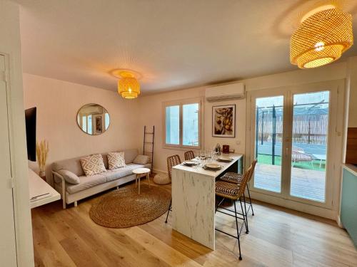 un salon avec une table et un canapé dans l'établissement Cocon 2 pièces avec grande terrasse à Vauban, à Marseille