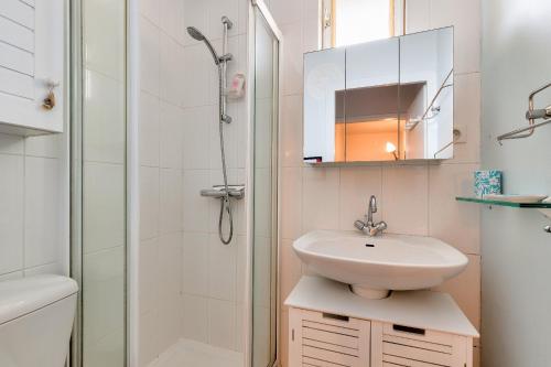une salle de bain blanche avec un lavabo et une douche dans l'établissement Maison de famille pour 6 personnes, à Les Sables-dʼOlonne
