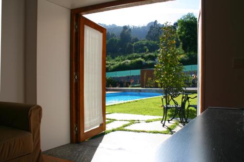 an open door to a patio with a view of a pool at Casa do Pomar - Eido do Pomar in Arcos de Valdevez