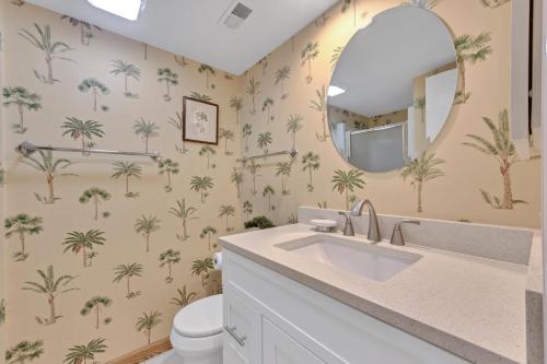 ein Badezimmer mit Palmen und einem Spiegel in der Unterkunft 1357 Pelican Watch in Seabrook Island