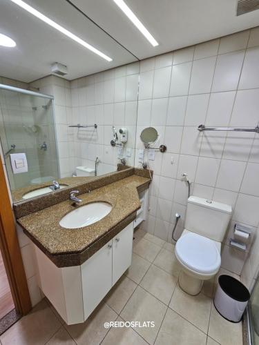 a bathroom with a toilet and a sink at Brasil 21 Convention By Rei dos Flats in Brasilia