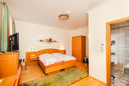 1 dormitorio con 1 cama y TV en Ferien beim Steiner, en Predlitz